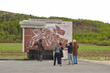 group of people discussing in front of war memorial